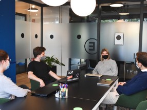 people with masks seeting in the meeting room at the table