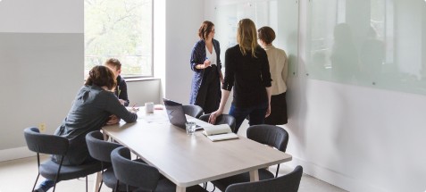 team members having a discussion at the table and the drawing board